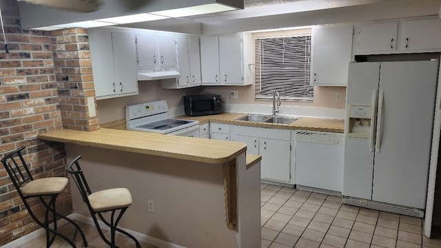 kitchen with kitchen peninsula, a kitchen breakfast bar, white appliances, sink, and white cabinetry