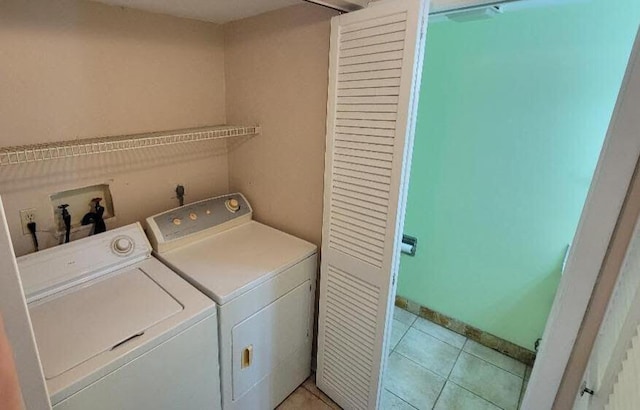 laundry area with light tile patterned floors and washer and clothes dryer