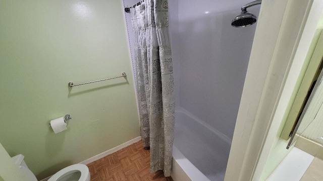 bathroom with parquet flooring, toilet, and shower / bath combo with shower curtain