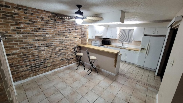 kitchen with white cabinetry, white appliances, kitchen peninsula, and a breakfast bar area