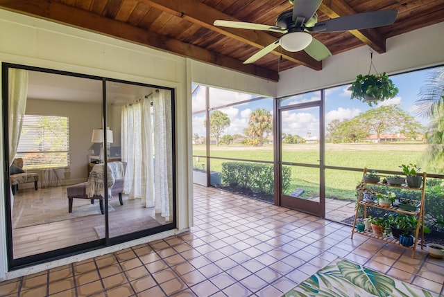 sunroom featuring beamed ceiling, ceiling fan, and wood ceiling