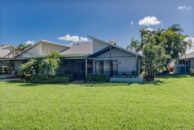 rear view of property featuring a sunroom and a yard