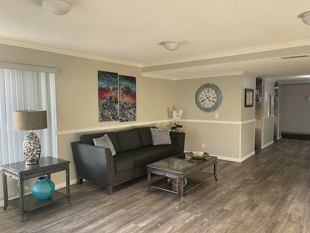 living area with visible vents, a textured ceiling, wood finished floors, and crown molding