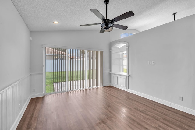 unfurnished room with a wealth of natural light, dark hardwood / wood-style flooring, ceiling fan, and lofted ceiling