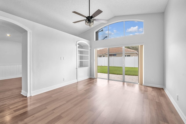 spare room with hardwood / wood-style flooring, ceiling fan, a textured ceiling, and high vaulted ceiling