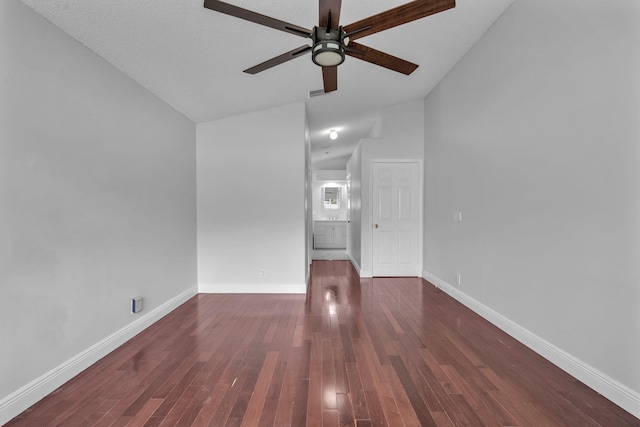 unfurnished living room featuring a textured ceiling, vaulted ceiling, ceiling fan, and dark wood-type flooring