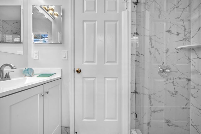 bathroom with tiled shower and vanity