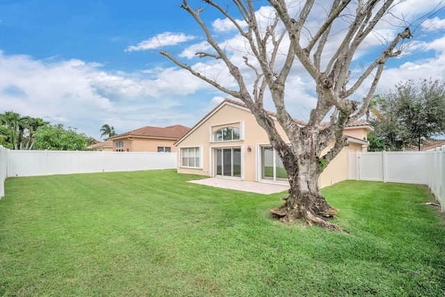 back of house featuring a lawn and a patio area