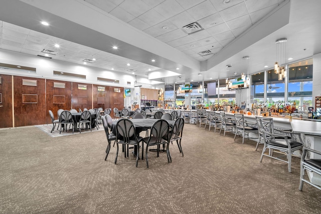 carpeted dining room featuring a drop ceiling