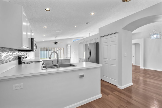 kitchen with white cabinets, appliances with stainless steel finishes, kitchen peninsula, and sink