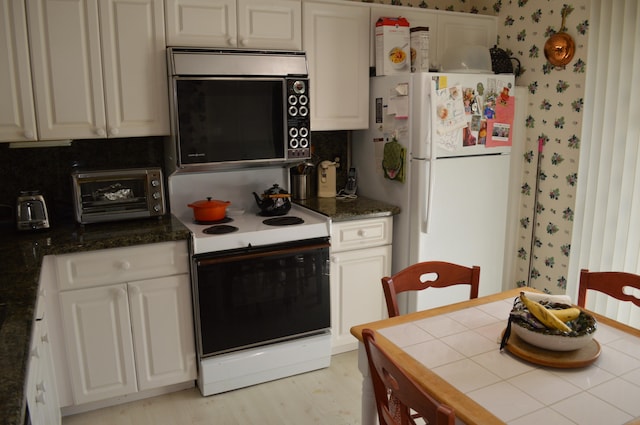 kitchen with white cabinetry, light wood-type flooring, and white appliances