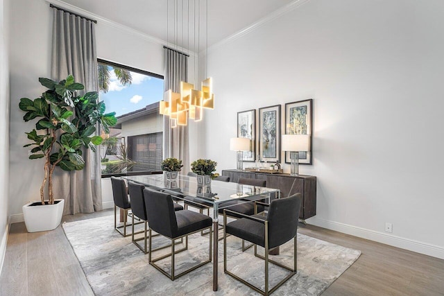 dining room with crown molding and light hardwood / wood-style floors