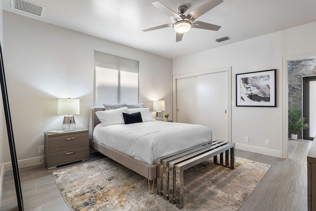 bedroom featuring ceiling fan, a closet, and light hardwood / wood-style floors