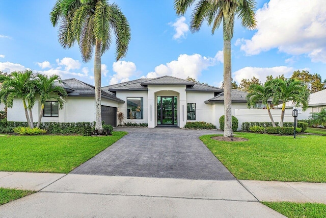 mediterranean / spanish-style house with a garage and a front lawn