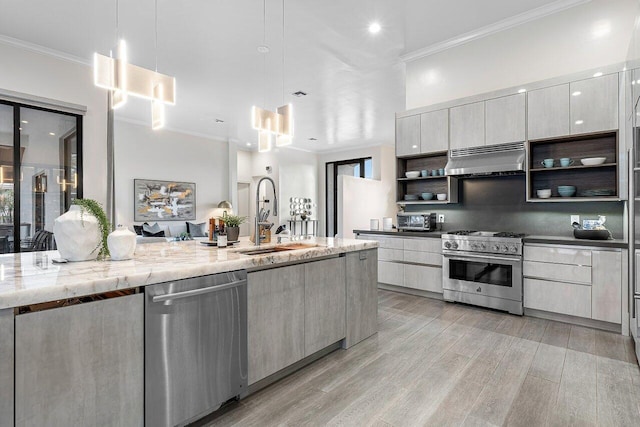 kitchen with sink, hanging light fixtures, appliances with stainless steel finishes, light hardwood / wood-style floors, and extractor fan