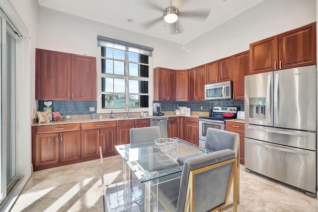 kitchen featuring tasteful backsplash, ceiling fan, sink, and appliances with stainless steel finishes