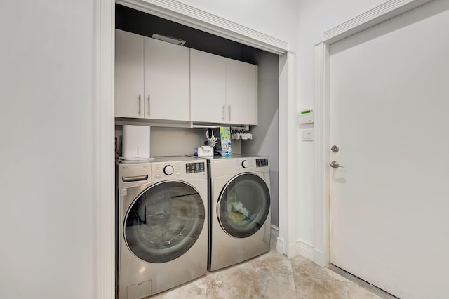 washroom with cabinets and washer and dryer