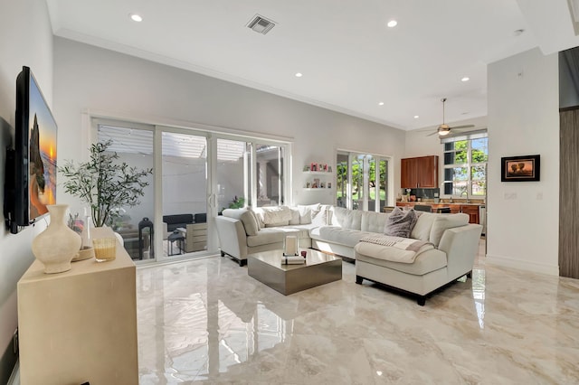 living room with ceiling fan, sink, and ornamental molding