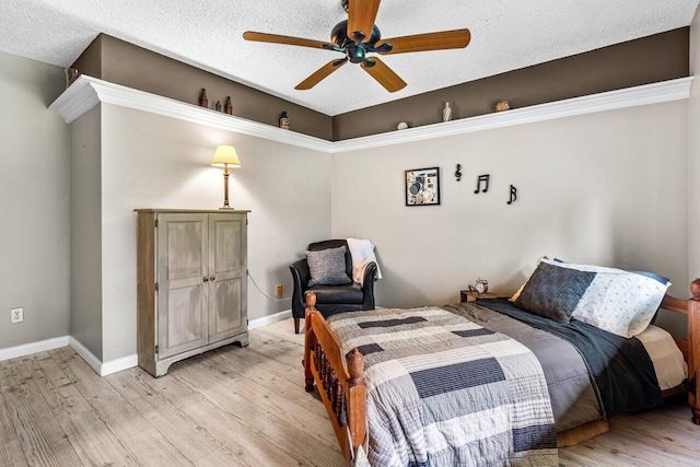 bedroom featuring ceiling fan, light hardwood / wood-style floors, and a textured ceiling