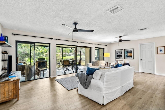 living room featuring light hardwood / wood-style flooring, a healthy amount of sunlight, and a textured ceiling