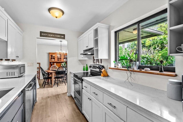 kitchen with white cabinets, appliances with stainless steel finishes, and light hardwood / wood-style flooring