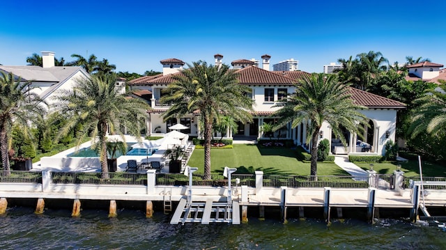 dock area featuring a water view, a lawn, a fenced backyard, and a patio area