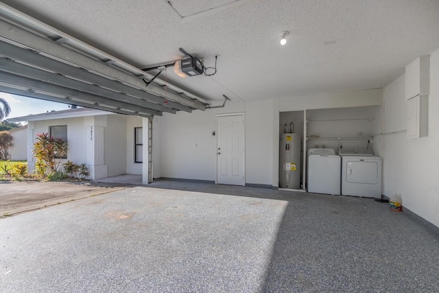 garage featuring washing machine and dryer, electric water heater, and a garage door opener