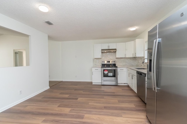 kitchen featuring white cabinets, sink, wood-type flooring, and stainless steel appliances