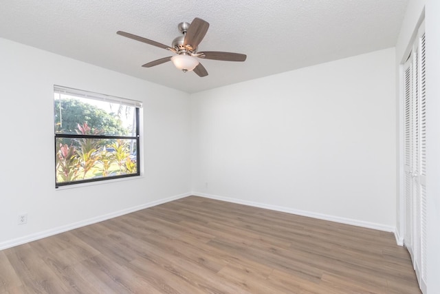 unfurnished bedroom featuring ceiling fan, light hardwood / wood-style floors, a textured ceiling, and a closet