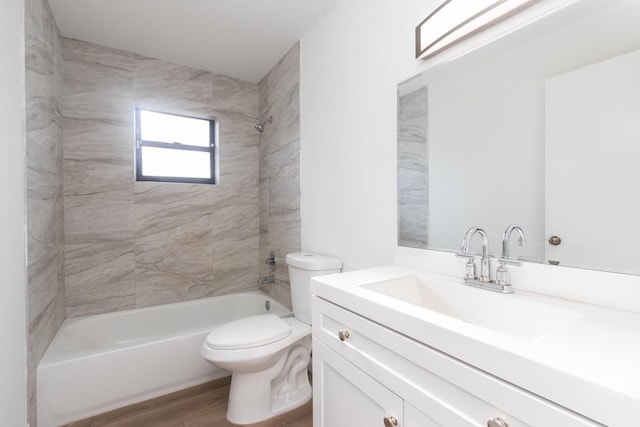 full bathroom with hardwood / wood-style floors, vanity, toilet, and tiled shower / bath combo