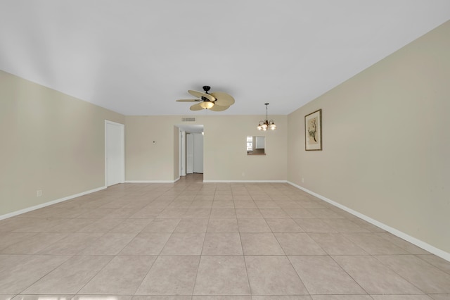 tiled empty room with ceiling fan with notable chandelier