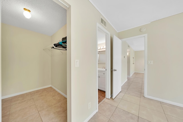 hallway with light tile patterned floors and a textured ceiling