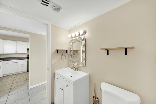 bathroom with toilet, vanity, tile patterned floors, and crown molding