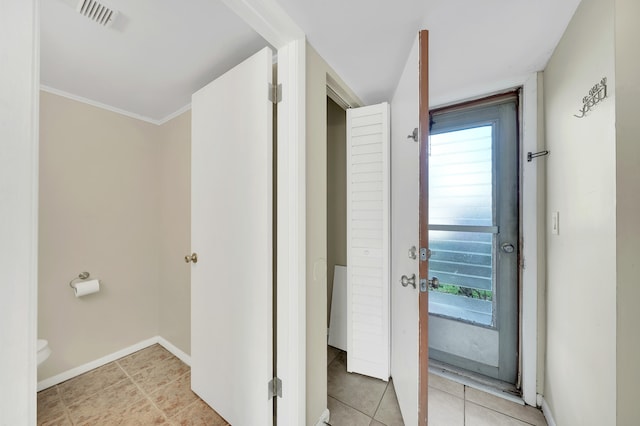 interior space featuring light tile patterned flooring and ornamental molding