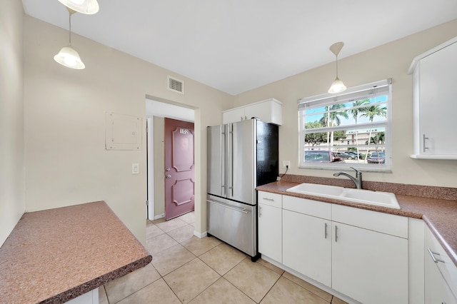 kitchen with high end refrigerator, white cabinetry, pendant lighting, and sink