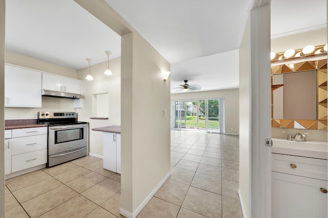 kitchen with stainless steel electric stove, ceiling fan, pendant lighting, light tile patterned floors, and white cabinets