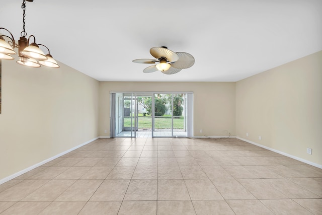 tiled empty room with ceiling fan with notable chandelier