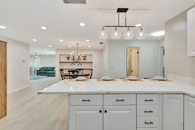 kitchen with visible vents, decorative light fixtures, recessed lighting, a peninsula, and white cabinets