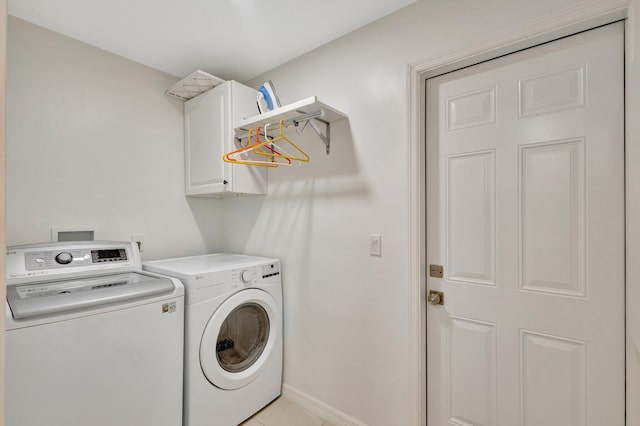 washroom with independent washer and dryer, cabinet space, and baseboards