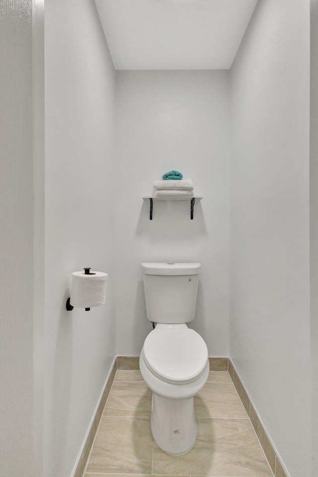 bathroom with toilet and baseboards