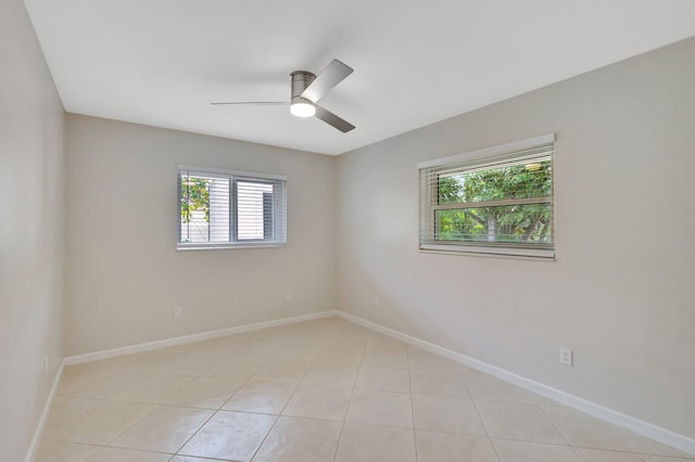 empty room featuring ceiling fan, baseboards, and light tile patterned floors