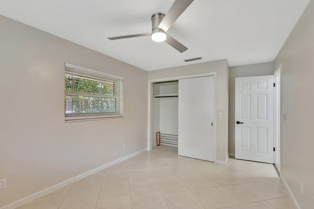 unfurnished bedroom featuring a closet, visible vents, baseboards, and light tile patterned floors