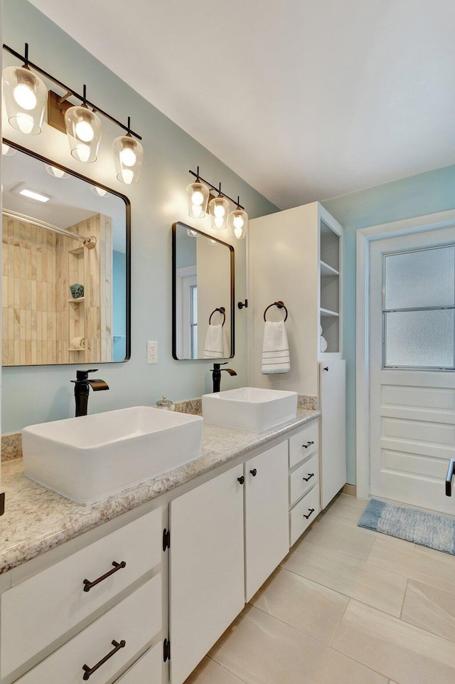 full bathroom with a sink, a shower, double vanity, and tile patterned flooring