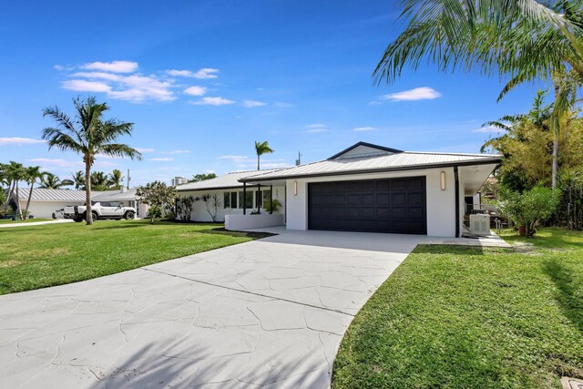 ranch-style house featuring central AC, a garage, and a front lawn