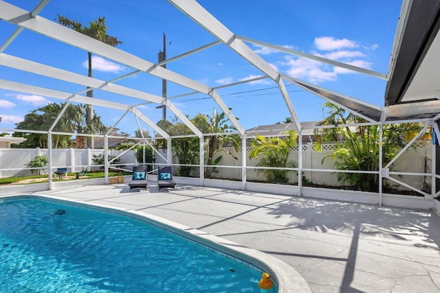 view of pool featuring a patio area, a fenced backyard, a fenced in pool, and a lanai