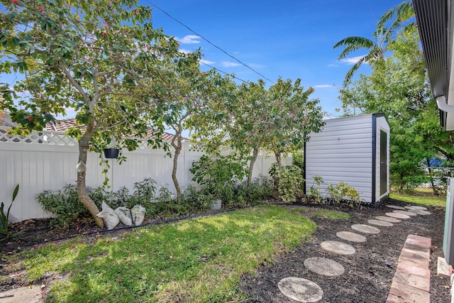 view of yard featuring an outdoor structure, a fenced backyard, and a storage shed