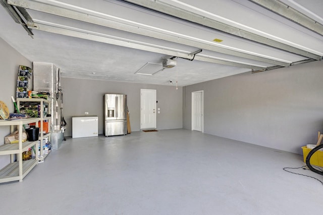 garage with stainless steel fridge, a garage door opener, and fridge