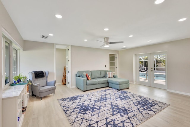 living area featuring light wood-style flooring, recessed lighting, visible vents, baseboards, and french doors