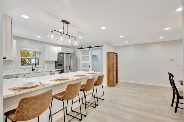 kitchen featuring a barn door, a kitchen bar, a sink, and appliances with stainless steel finishes