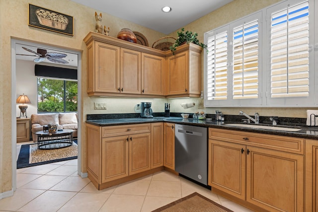 kitchen featuring light tile patterned flooring, dishwasher, dark stone counters, and sink